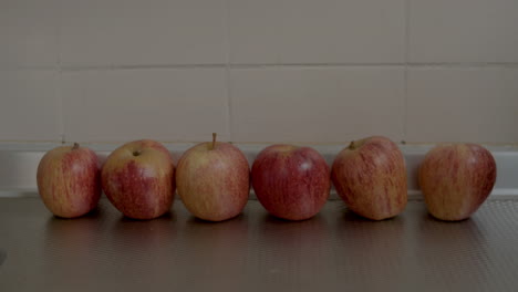 manos femeninas colocando manzanas en el mostrador de la cocina