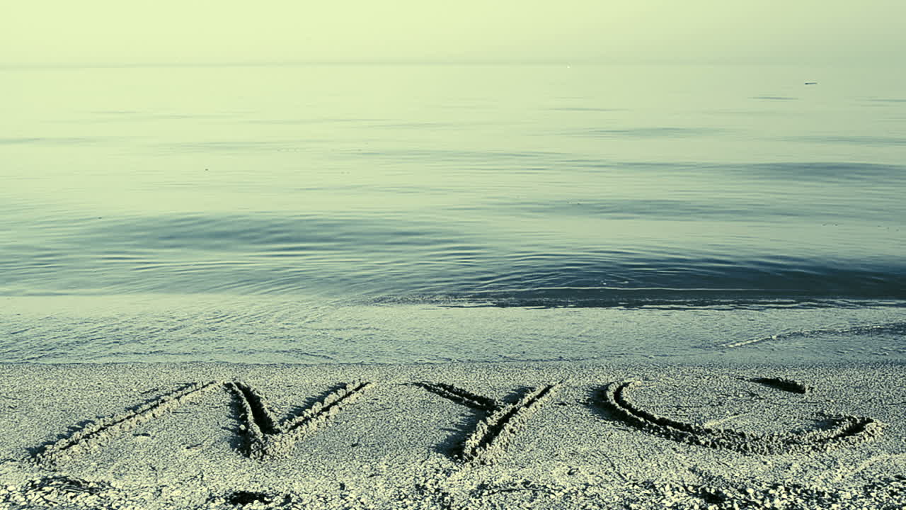 The inscription NYC on sand. Inscription on sand, the beach