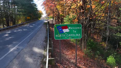 Welcome-to-North-Carolina-sign-under-yellow-foliage-during-autumn