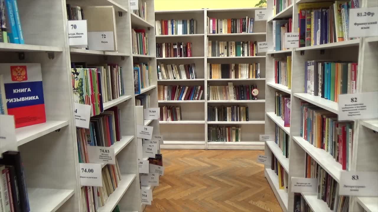 Organized bookshelves filled with diverse titles in a library. 4K