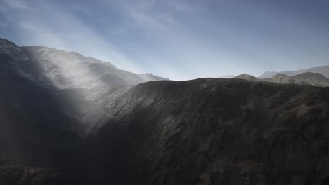 sun rays over mountains in a valley