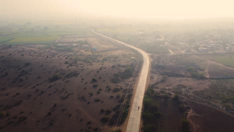 aerial drone shot of a village rural road through farmlands during afternoon time in madhya pradesh india