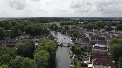 Vista-Aérea-Del-Puente-Levadizo-Sobre-El-Río-Vecht-Y-La-Torre-De-La-Iglesia-En-Loenen,-Países-Bajos