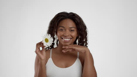 smiling woman holding a daisy