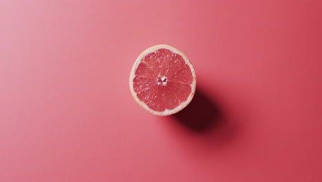 video of sliced red grapefruit with copy space over red background