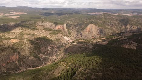 drone image in mountainous landscape with pine trees and a small town