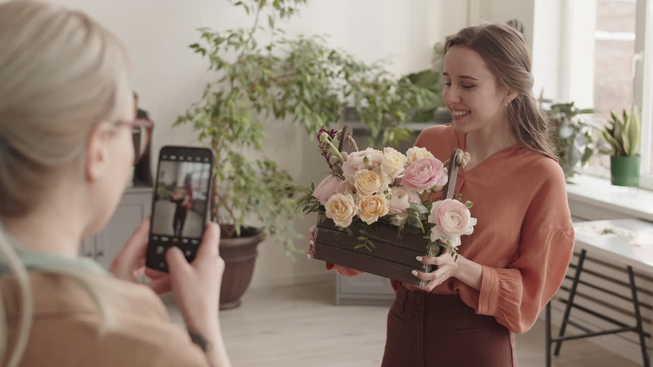 Mulher fotografando arranjo de flores