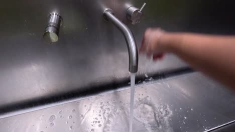 person washing hands under running water