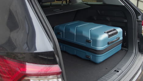 man get all the travel bags in the trunk of his car