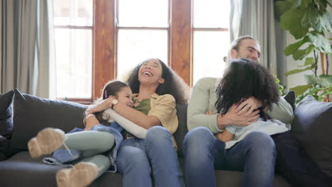 family, hug and parents with children on a sofa