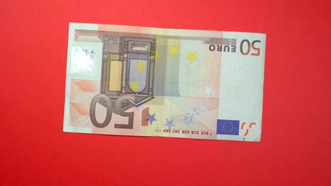 50 euro fast spinning on a rotating red background.
