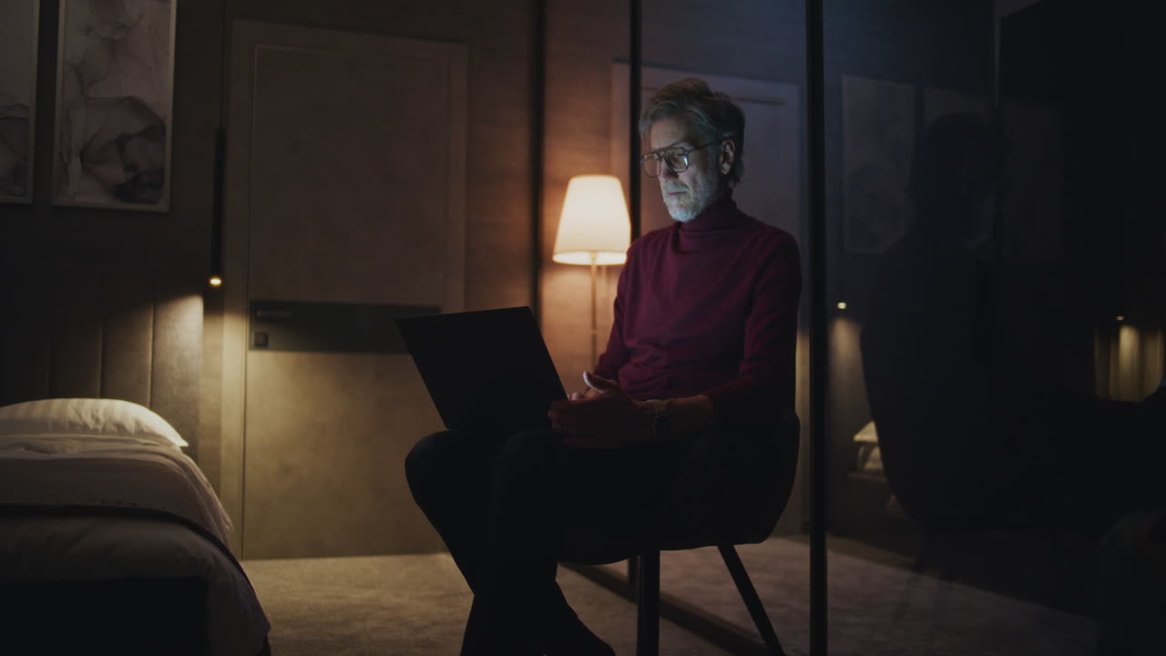 밤에는 침실에서 노트북으로 일하는 남자