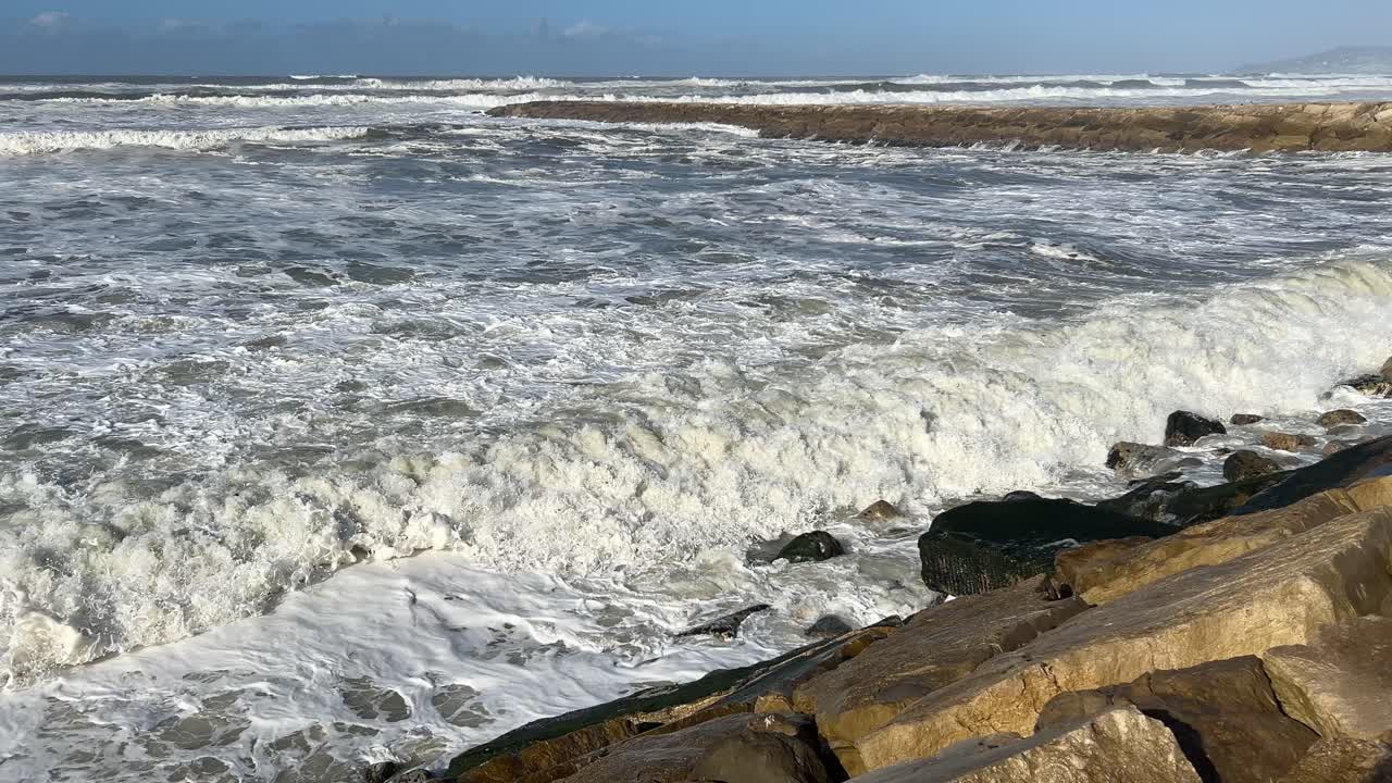 Mare in tempesta che si infrange contro il frangiflutti