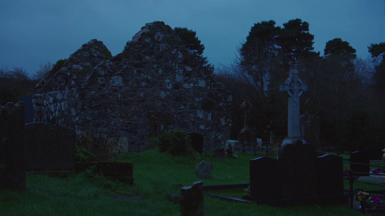 Rovine di un'antica chiesa in pietra con tombe, Irlanda al tramonto