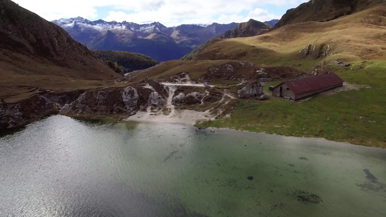 vista aérea del hermoso paisaje montañoso con un lago azul profundo y un edificio muy antiguo, colores otoñales en las montañas suizas