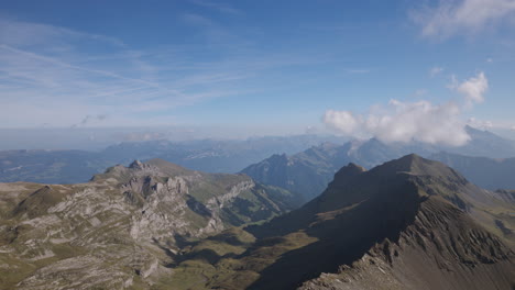 the cable car provides an awe-inspiring vista of mountains, showcasing clouds tucked beneath the expansive blue sky