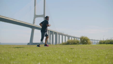 tracking shot of athlete with prosthetic leg jogging in park.