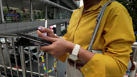 woman using tablet on a city bridge