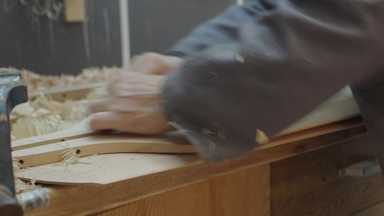 Skilled Hands Smoothing Wood with Sandpaper in Workshop