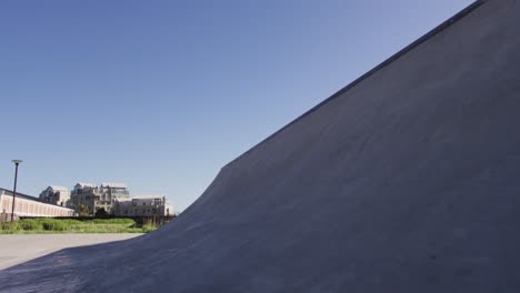 caucasian man riding and jumping on skateboard on sunny day