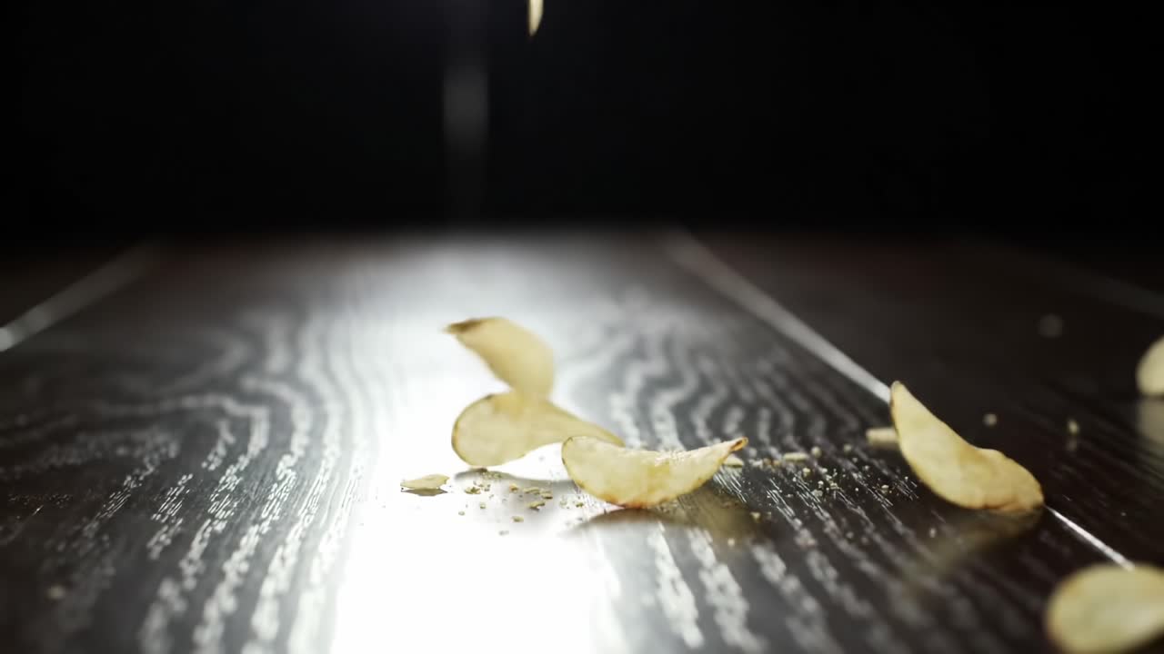 Captivating Slow-Motion Sequence of Crispy Potato Chips Falling and Crumbling on a Polished Surface, Highlighting Texture and Sound in a Unique Culinary Beauty