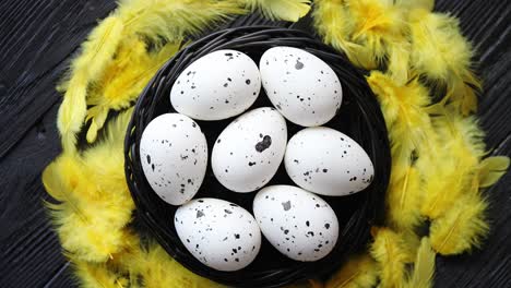 whole chicken eggs in a nest on a black rustic wooden background  easter symbols