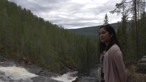 girl admires waterfall in the forest