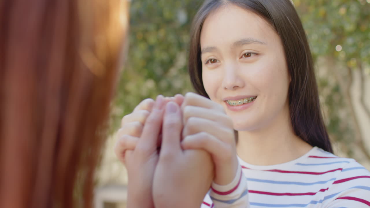 Smiling woman holding hands with another person, sharing tender moment