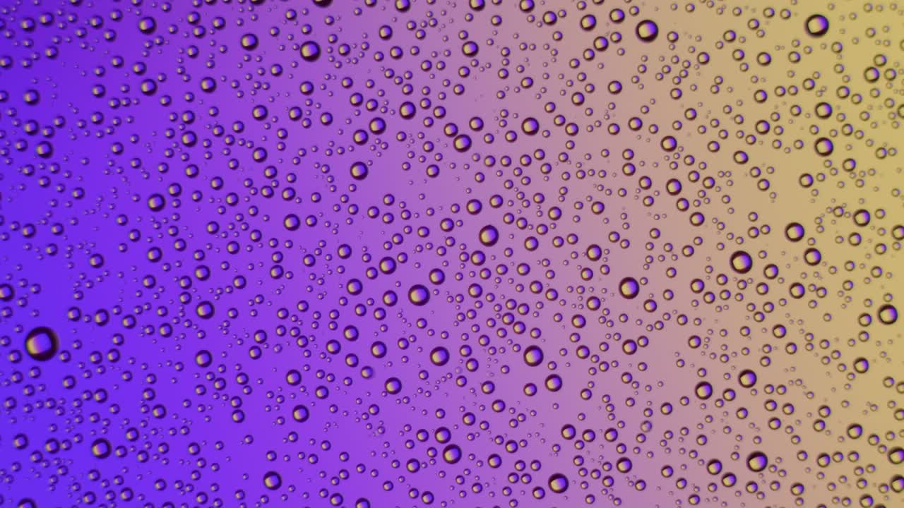 Water drops on glass surface on purple and yellow