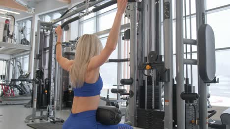woman working out on a lat pulldown machine in a gym