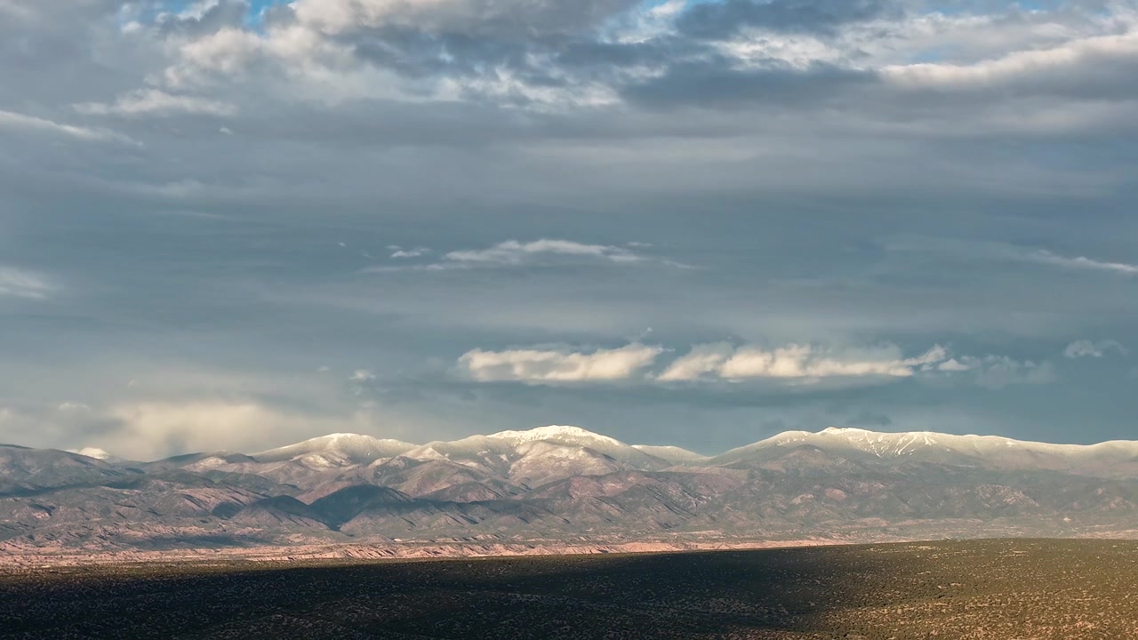 Timelapse 4K con drone cattura cieli drammatici grigio cromo su una catena montuosa aspra. Il movimento atmosferico cinematografico rivela nuvole scure in movimento e maltempo che si addensa su un panorama ad alta quota