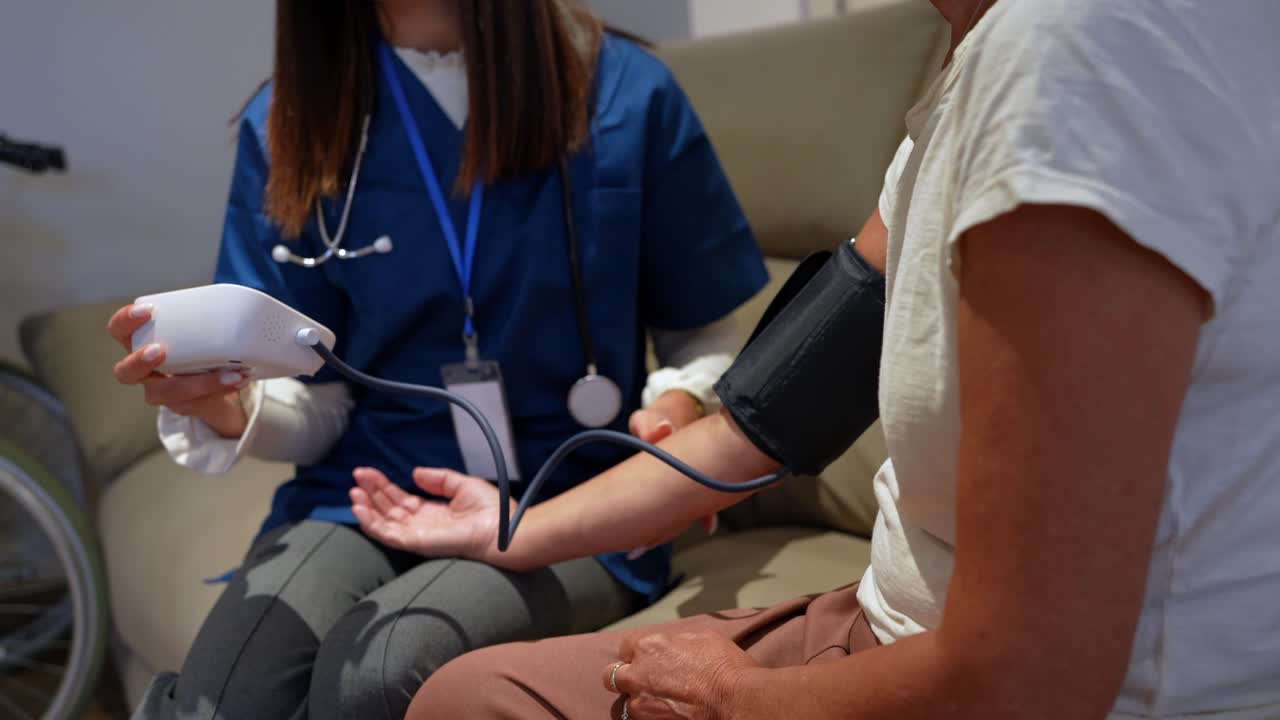 Nurse checking blood pressure of a patient at home