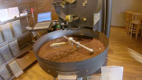 granos de café girando lentamente en la bandeja de enfriamiento después de ser asados