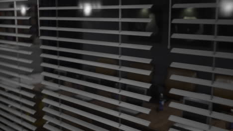 Looking through blinds at a quiet modern space in the evening light
