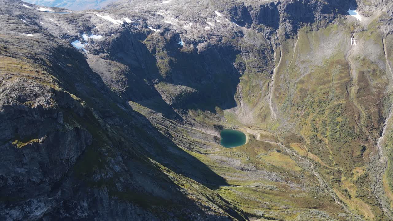 Small mountain lake deep in a valley in Western Norway. Drone footage