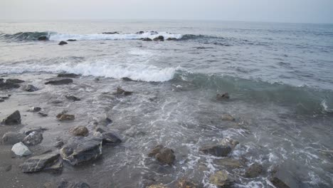 light surf gently washes in as the cool morning light shines on the rocky beach near cala de mijas on the costa del sol in southern spain