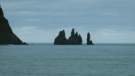 Slow-motion-footage-of-ocean-waves-on-Black-Sand-Beach-Reynisfjara-with-Reynisdrangar---basalt-sea-rocks-situated-under-the-mountain-Reynisfjall,-near-Vik-i-Myrdal-village-in-Iceland