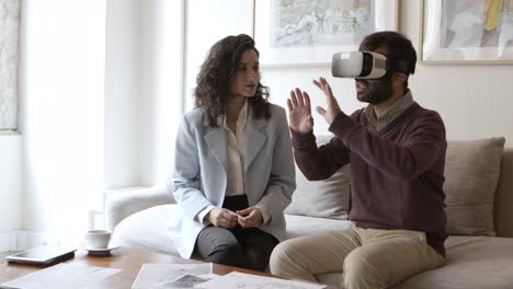 hombre caucásico con auriculares de realidad virtual y hablando con el diseño de interiores