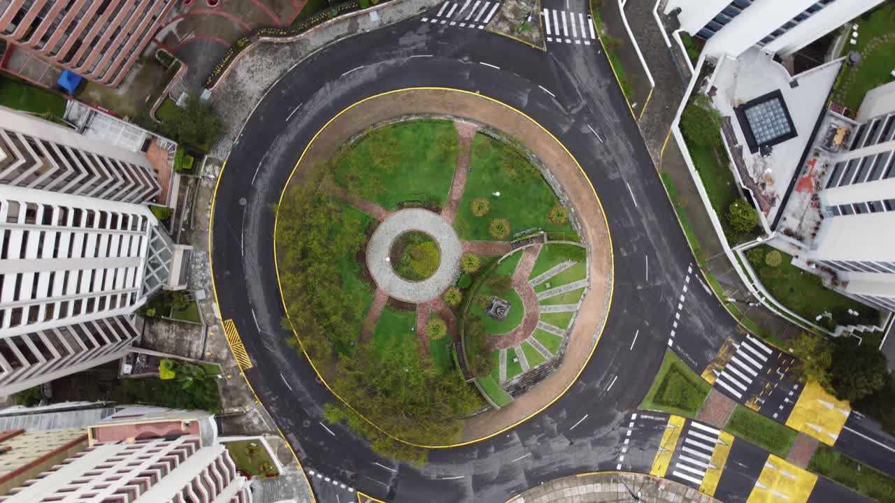 calle pavimentada en un círculo con la naturaleza en el centro, tráfico y estilo de vida en una ciudad con edificios, américa latina en quito, ecuador, arquitectura