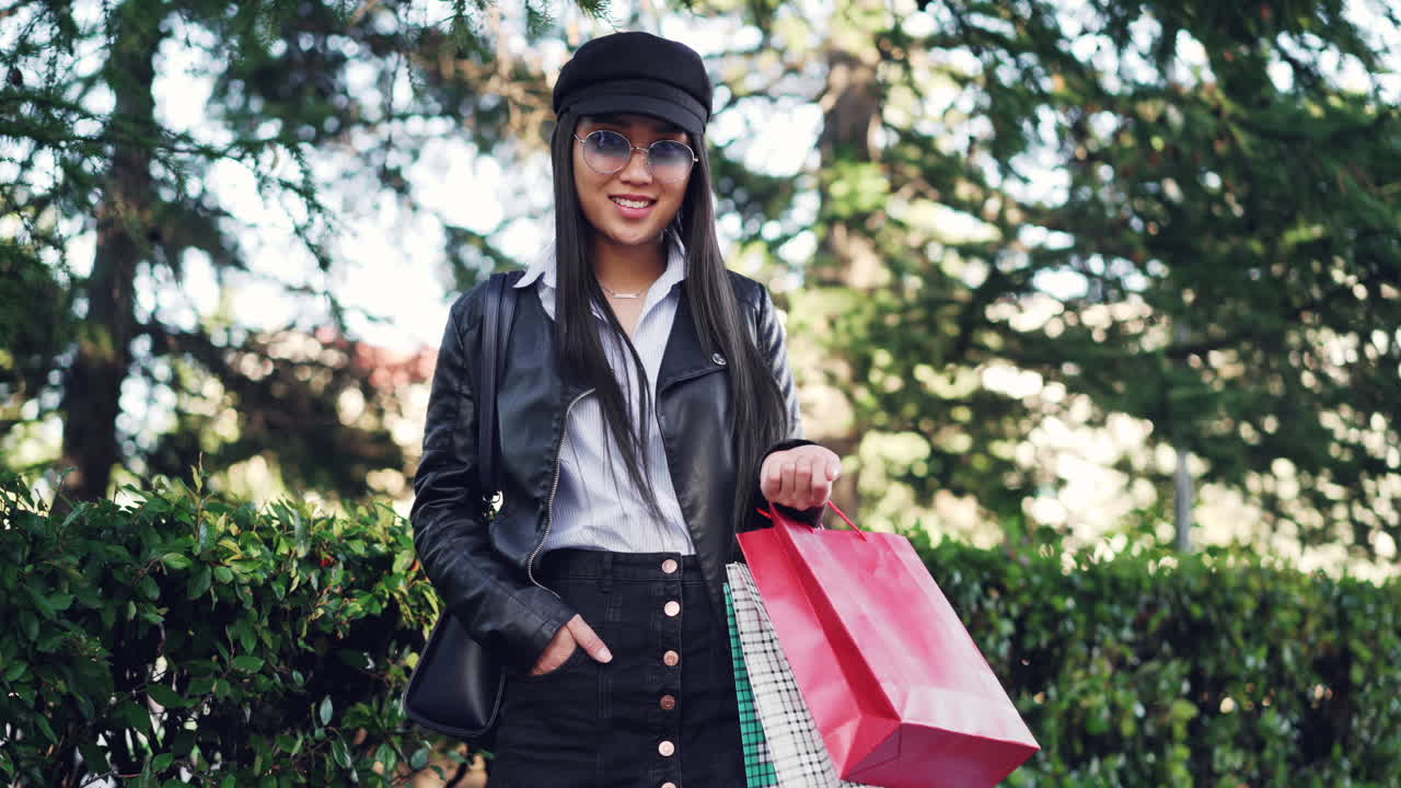 Stylish woman with shopping bags in a park