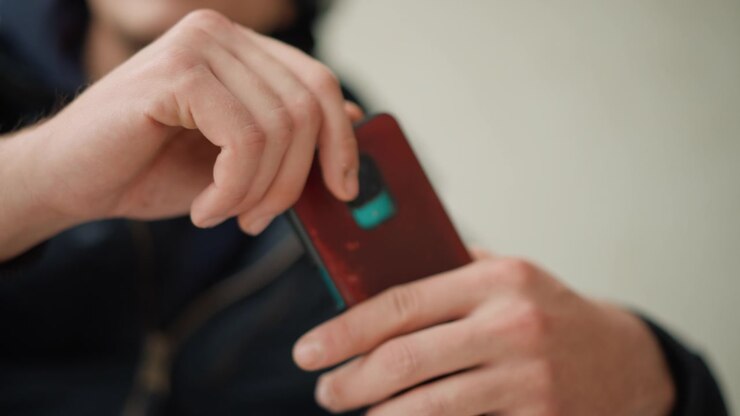 Close up of man hands holding and interacting with various electronic devices including smartphones tablets or small gadgets. focus remains on precise movements such as tapping screens