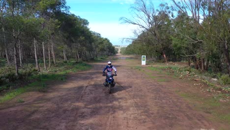 A-Dirt-Bike-Motorcycle-Rider-Drives-On-A-Backroad-Area-With-Some-Large-Water-Puddles-2