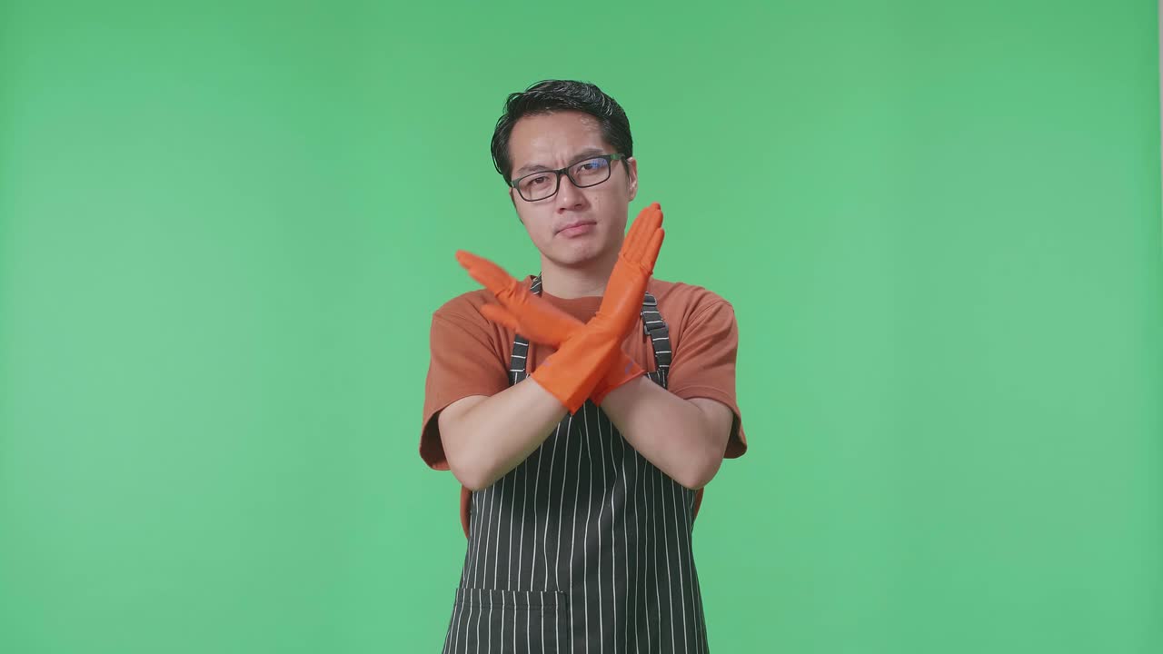 앞옷과 오렌지색 장갑을 입은 남자가 무언가를 거부하고 있습니다.