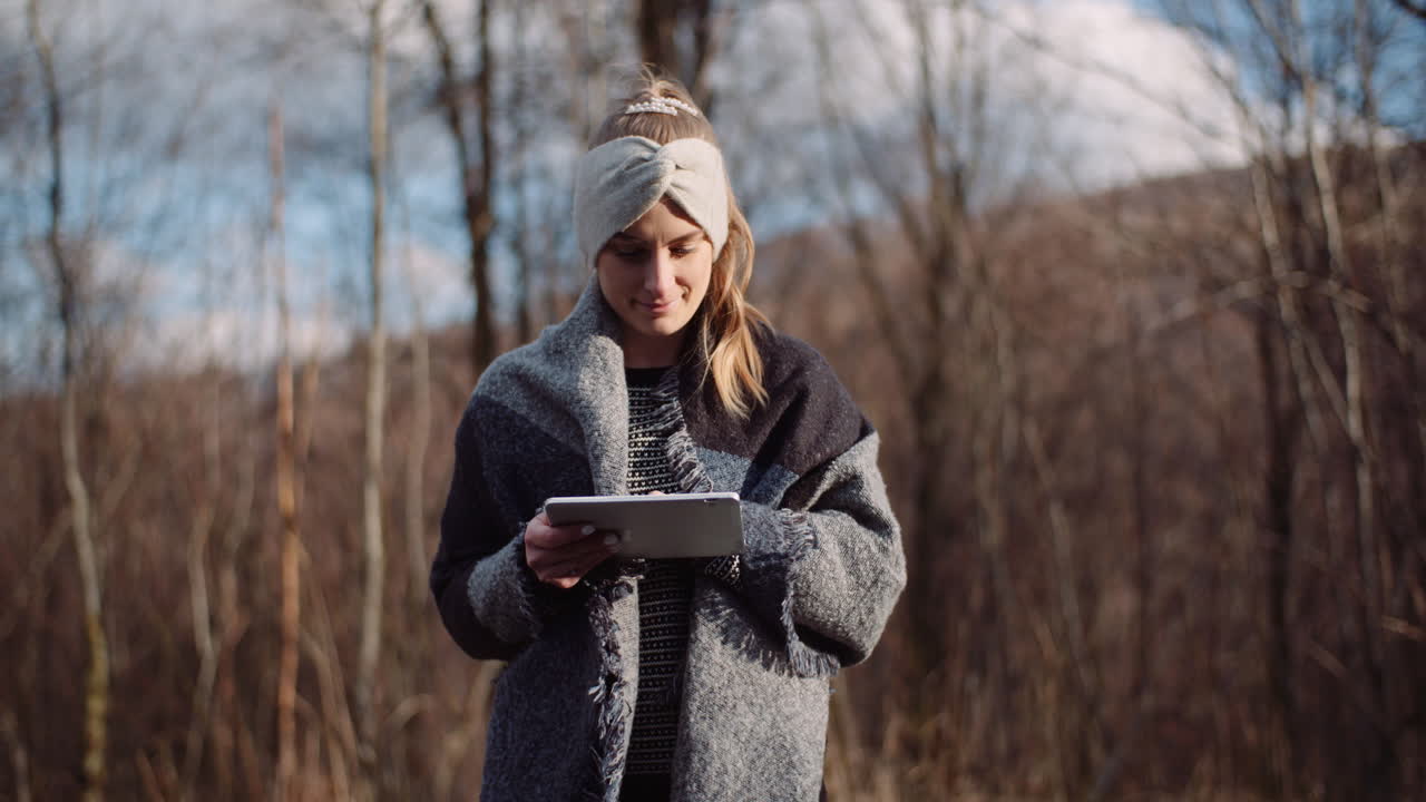 Wanderin macht Pause in den Bergen und benutzt ein digitales Tablet 1