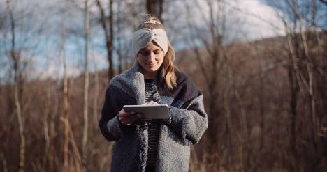 female tourist taking brake in mountains and use digital tablet 1