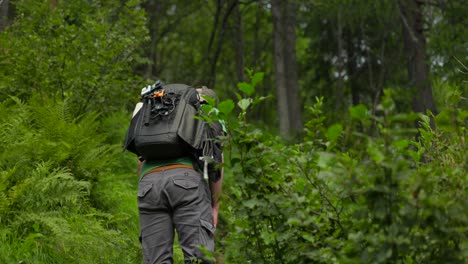 Creador-De-Contenido-Masculino-Camina-Por-Un-Sendero-Forestal-Trepador,-Vista-Trasera