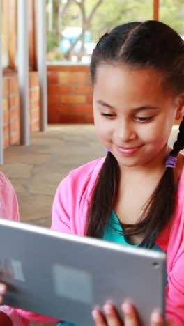 grupo de escolares que usan tabletas digitales y computadoras portátiles en el campus