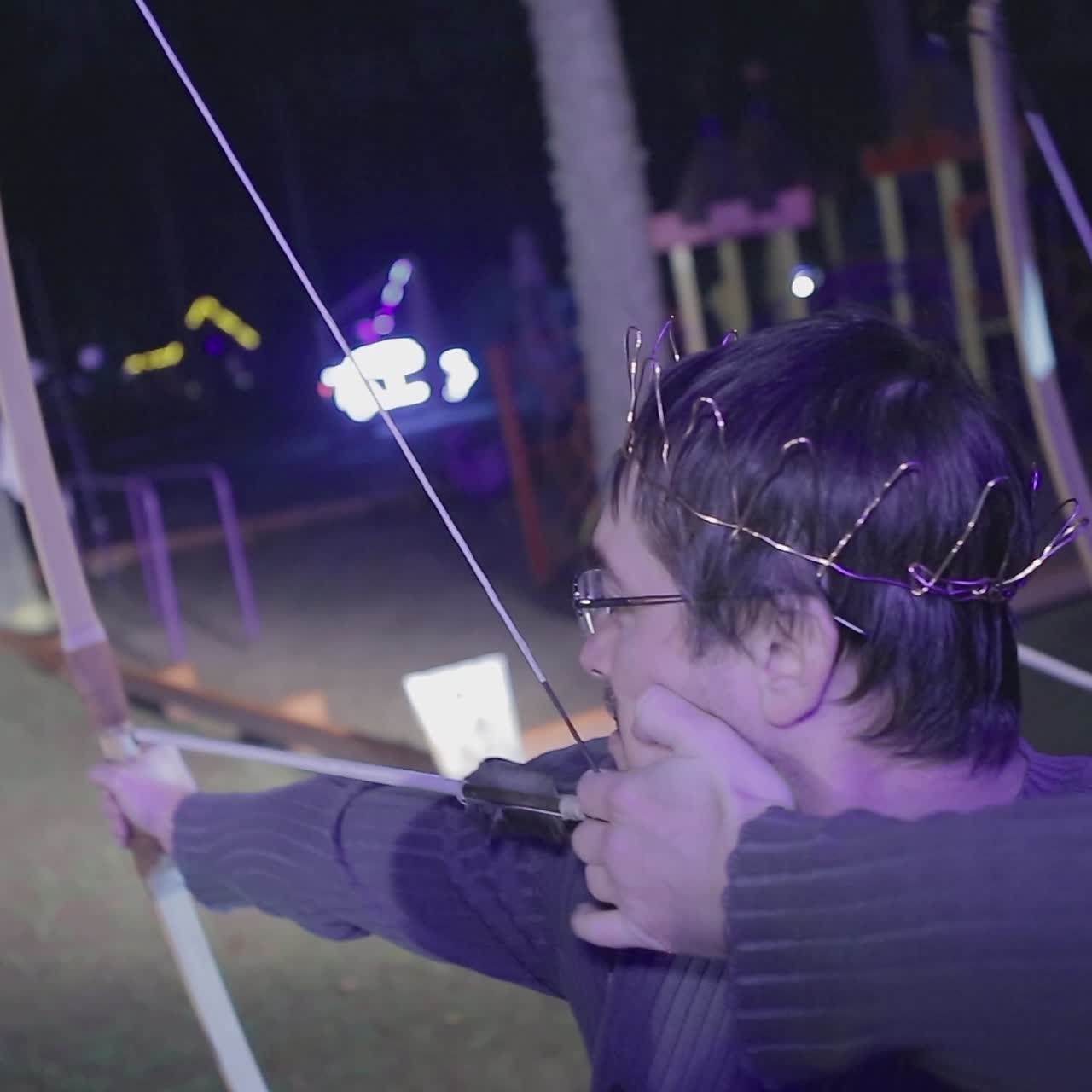 Man Aims A Bow At A Target