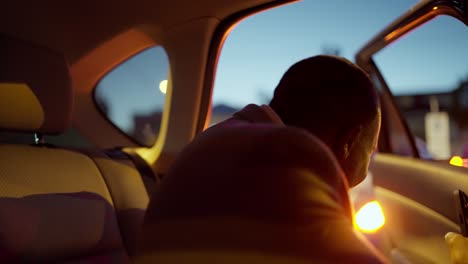 A-happy-and-cheerful-Black-skinned-man-with-a-beard-and-a-brown-suit-businessman-gets-out-of-his-modern-car-and-heads-to-a-meeting-place-in-the-city-in-the-evening