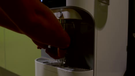 el hombre presiona el botón del refrigerador y se lava la mano con el reloj